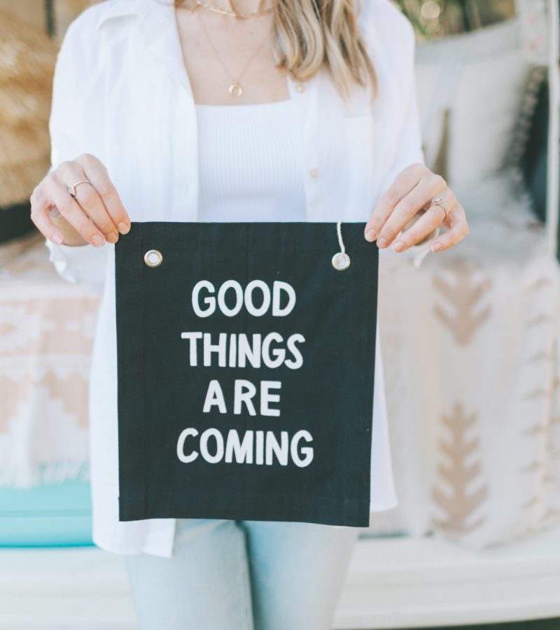 woman holding poster that says good things are coming